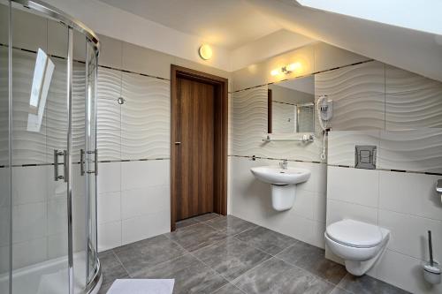 a bathroom with a toilet and a sink and a shower at Hotel Kamieniczka in Legnica