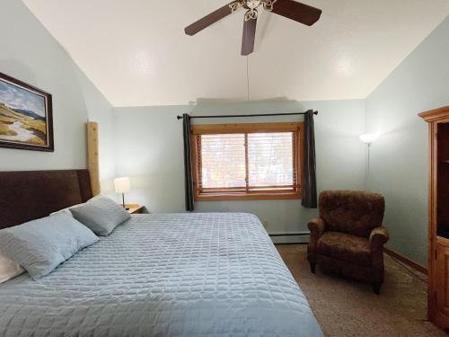 um quarto com uma cama, uma ventoinha de tecto e uma cadeira em Cabin A Suite Bed and Breakfast em Woodland Park