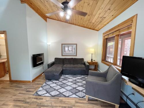 a living room with a couch and a flat screen tv at Cabin A Suite Bed and Breakfast in Woodland Park