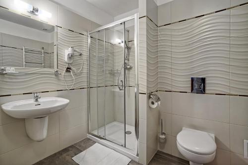 a bathroom with a shower and a toilet and a sink at Hotel Kamieniczka in Legnica