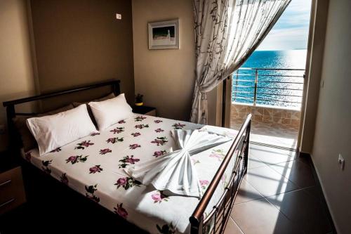 a bedroom with a bed with a view of the ocean at Cavo Paradise in Sarandë