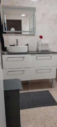 a white bathroom with a sink and a mirror at Maison de village type 2 in Sainte-Croix-de-Verdon