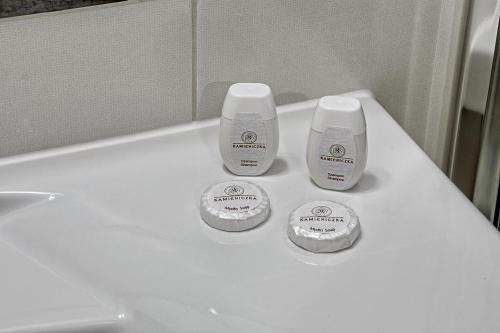 a white bathroom counter with twoentedented products on it at Hotel Kamieniczka in Legnica