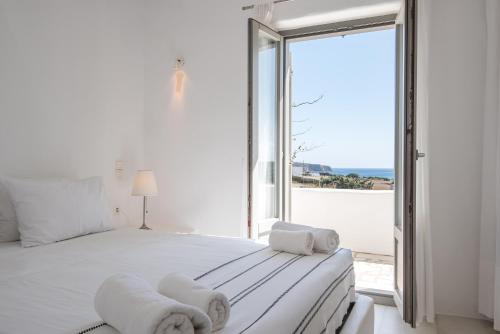 una camera da letto con un grande letto bianco e una grande finestra di Aeraki Villas a Santa Maria