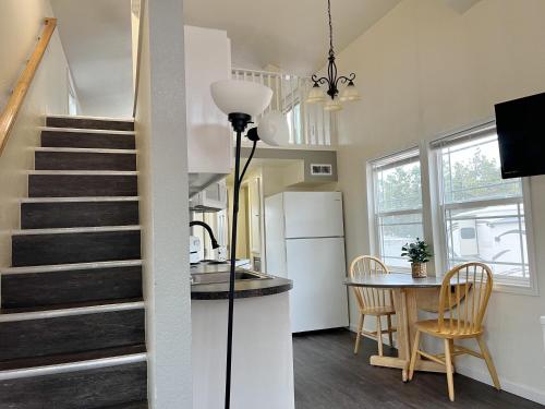 a kitchen and dining room with a staircase and a table at Cedar Tiny Home in Woodland Park