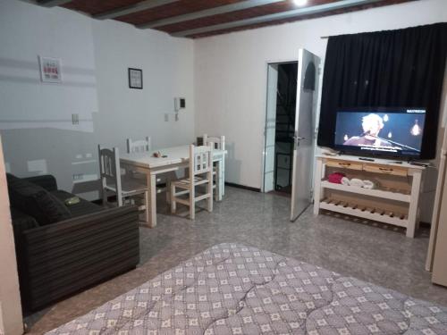 sala de estar con TV de pantalla plana y mesa en Galeano Aparts en Santa Rosa