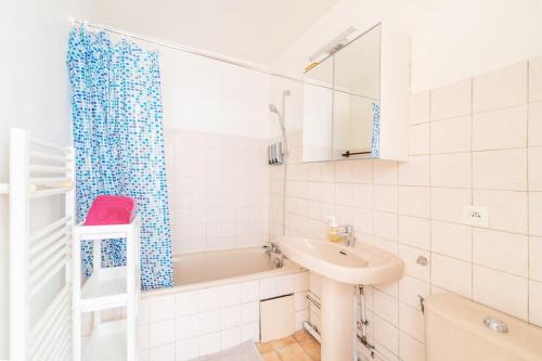een witte badkamer met een wastafel en een bad bij EMbnb - Studio Near Geneva in Étrembières