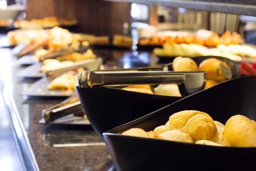 a counter filled with lots of different types of food at Monumental Bittar Hotel in Brasília