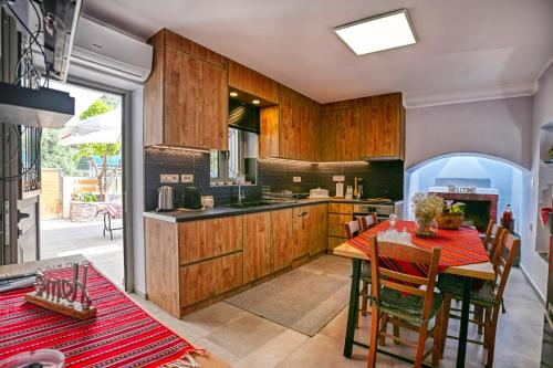 Una cocina con gabinetes de madera y una mesa con sillas. en Haroto Home Residence, en Plokamianá