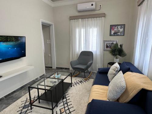 sala de estar con sofá azul y TV en Irene's house en Kalymnos