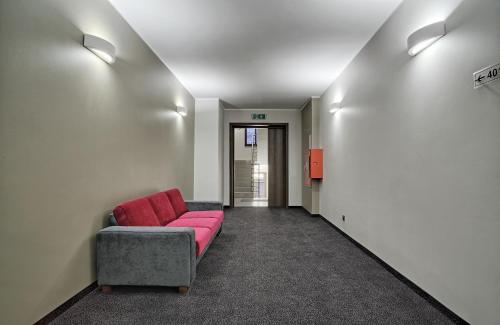 a living room with a pink couch in a hallway at Hotel Kamieniczka in Legnica