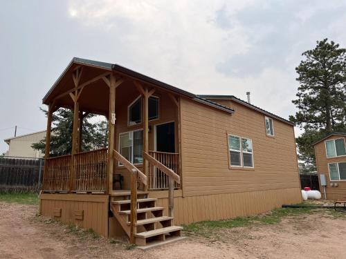a large house with a porch and a deck at Alder Tiny Home in Woodland Park