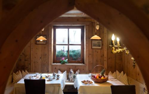 a dining room with two tables and a window at Hotel Cavallino D'Oro Bed&Breakfast in Castelrotto