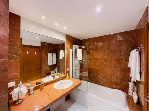 ein Badezimmer mit einer Badewanne, einem Waschbecken und einer Badewanne in der Unterkunft Casino Villa with Sea View in Funchal