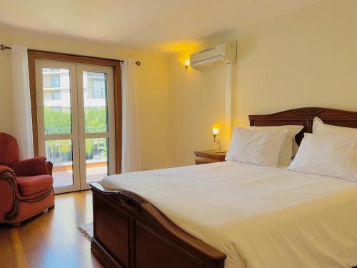 een slaapkamer met een groot wit bed en een raam bij Casino Villa with Sea View in Funchal