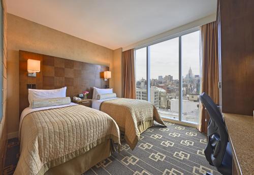 a hotel room with two beds and a large window at Wyndham Garden Chinatown in New York