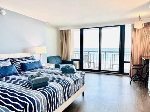 um quarto com uma cama com almofadas azuis em *OCEANFRONT SUNNY FUN*Queen Beds *Great Pools, Hot Tubs+*M44 em Myrtle Beach