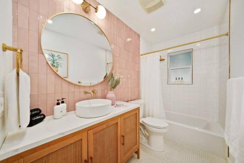 uma casa de banho com um lavatório, um WC e um espelho. em Luxury Beach House Oasis 3 Blocks from the Beach em Cape Canaveral