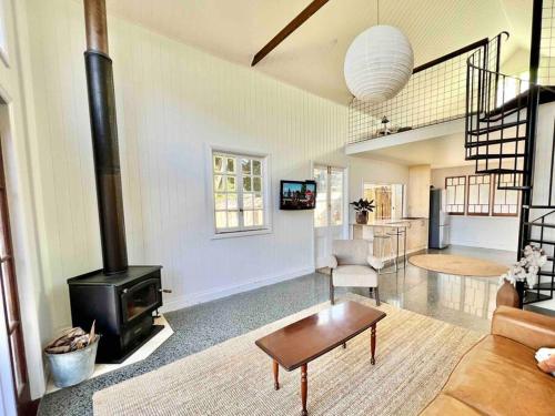 a living room with a fireplace and a stove at The Old Shop - Byron Region Hinterland 