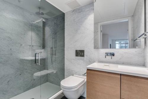 a bathroom with a toilet and a shower and a sink at Modern studio in Downtown Vancouver in Vancouver