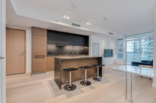 a kitchen with a counter and stools in a room at Modern studio in Downtown Vancouver in Vancouver