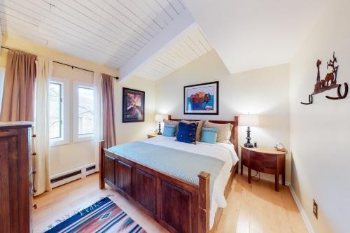 a bedroom with a large bed and a table at Peaceful Woodbridge Hideaway in Snowmass Village