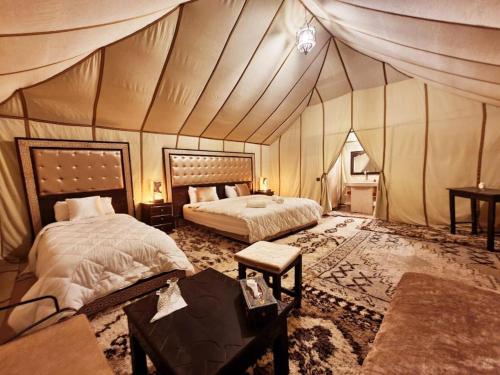 a bedroom with two beds in a tent at Sunset Camp Merzouga in Merzouga