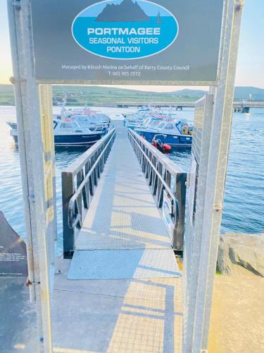 a sign for a pier with boats in the water at Portmagee Village Apartments in Portmagee