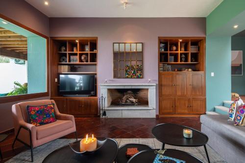 a living room with a fireplace and a tv at HOLT Balcones Guesthouse - Two Double Beds Room in San Miguel de Allende