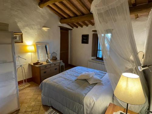 a bedroom with a bed with a mosquito net at Fontecristina in Collebaldo