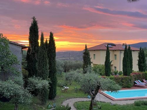 a villa with a swimming pool and a sunset at Fontecristina in Collebaldo