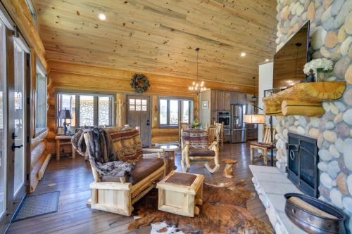 a living room with a fireplace and a stone wall at Cozy Riverfront Cabin about 1 Mi To Buena Vista in Buena Vista