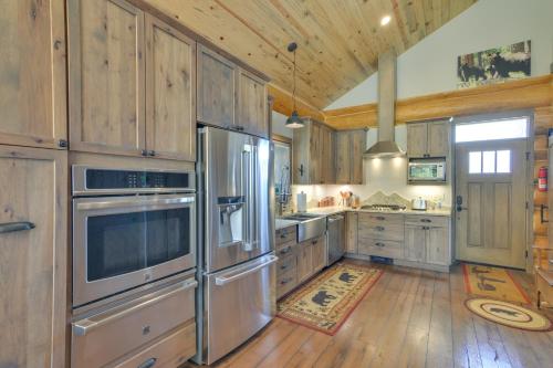 a kitchen with wooden cabinets and stainless steel appliances at Cozy Riverfront Cabin about 1 Mi To Buena Vista in Buena Vista