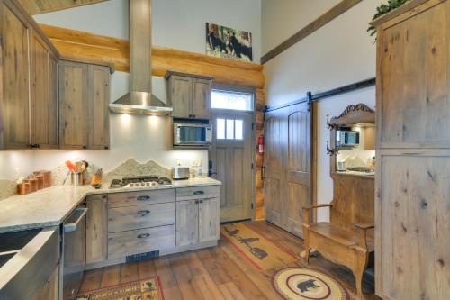 a kitchen with wooden cabinets and a stove top oven at Cozy Riverfront Cabin about 1 Mi To Buena Vista in Buena Vista