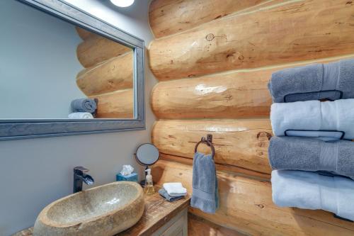 a bathroom with a wooden wall with a sink and a mirror at Cozy Riverfront Cabin about 1 Mi To Buena Vista in Buena Vista