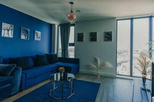 een blauwe woonkamer met een blauwe bank bij Luxury Apartment Retreat - FREE Netflix And Wifi in Birmingham