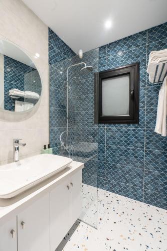 a bathroom with a sink and a shower with a tv at Nabeel Homes - Seaview Building - 3 Units in Gleem in Alexandria
