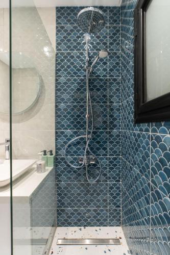 a bathroom with a shower with blue tiles at Nabeel Homes - Seaview Building - 3 Units in Gleem in Alexandria