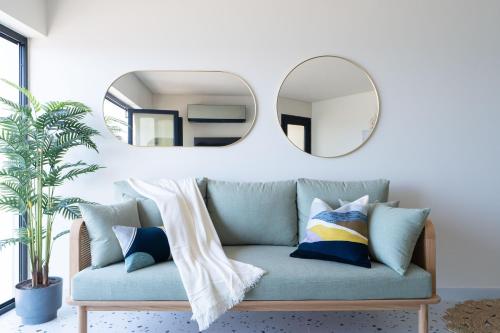 a living room with a couch and a mirror at Designer Seaview Condo in Gleem in Alexandria