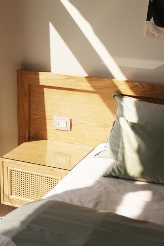 a bed with a wooden headboard and a night stand at Nabeel Homes - Seaview Building - 3 Units in Gleem in Alexandria
