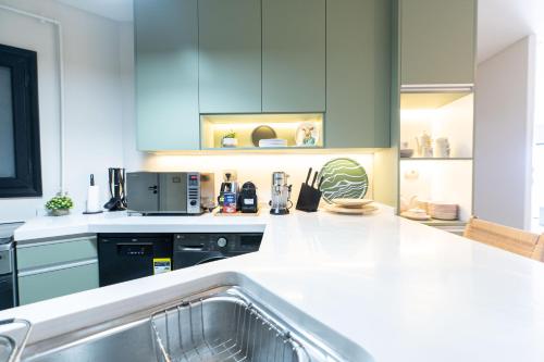 a kitchen with blue cabinets and a white counter top at Nabeel Homes - Seaview Building - 3 Units in Gleem in Alexandria