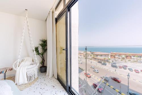 a room with a balcony with a view of the ocean at Nabeel Homes - Seaview Building - 3 Units in Gleem in Alexandria