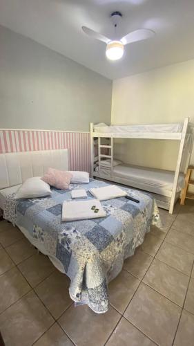 a bedroom with a bed and two bunk beds at Alfa Mar Pousada in Abraão