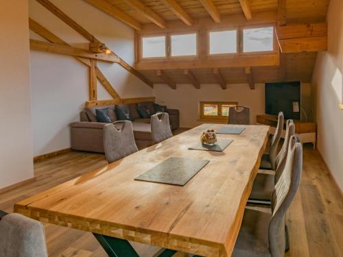 a dining room with a wooden table and a couch at Schlafhamhof in Hopfgarten im Brixental