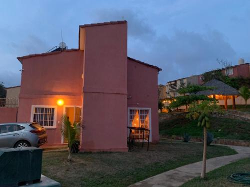a pink house with a car parked in front of it at sweet home ixtapa comfort in Ixtapa