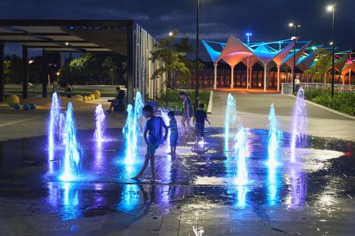 a group of children playing in a fountain at night at Hatea Treehouse in Whangarei