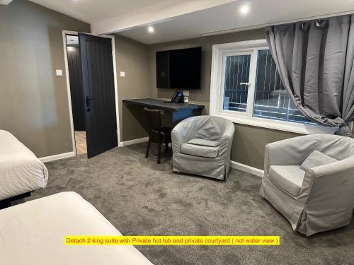 a hotel room with a bed and a desk and chairs at TheWaterfrontLodges in Coventry