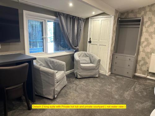 a room with two chairs and a desk and a window at TheWaterfrontLodges in Coventry