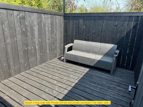 a bench sitting on a wooden deck with a fence at TheWaterfrontLodges in Coventry