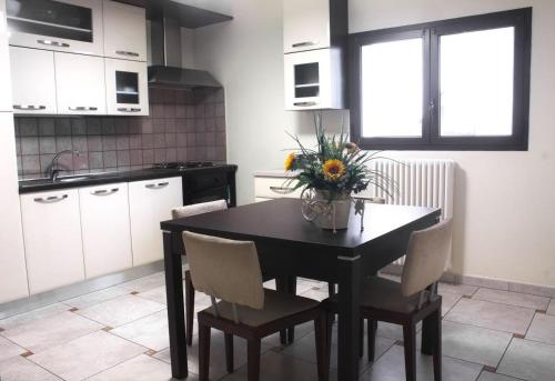 a kitchen with a table with a vase of flowers on it at Appartamento Ghalà in Galatone